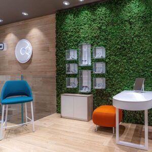 foto di negozio di ottica che ritrae teche espositive di montature di occhiali incassate su parete di verde verticale MossWall verde verticale stabilizzato per gioiellerie e ottiche