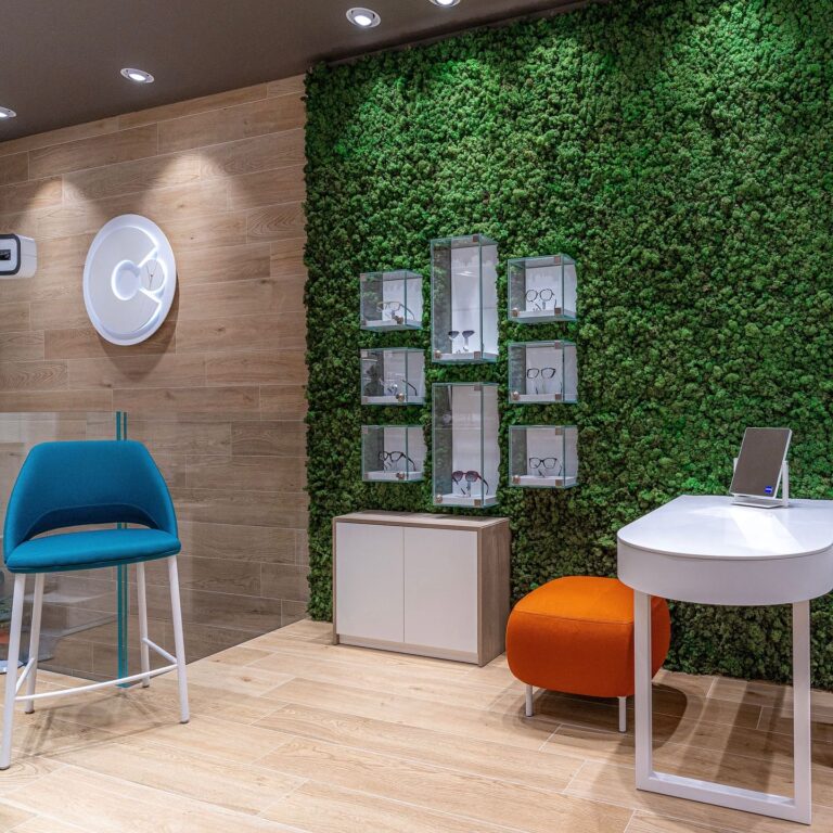 foto di negozio di ottica che ritrae teche espositive di montature di occhiali incassate su parete di verde verticale MossWall verde verticale stabilizzato per gioiellerie e ottiche